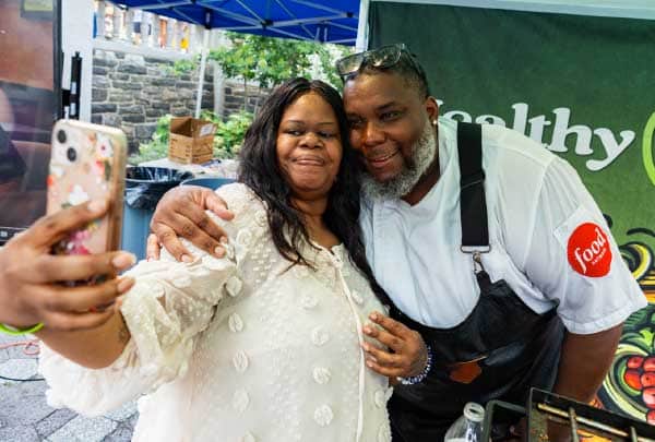 A visitor takes a selfie with Chef Timothy Witcher at a Healthy Choices community event
