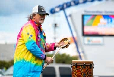 Facilitator Merk plays a drum outdoors during an adult and veteran wellness music session